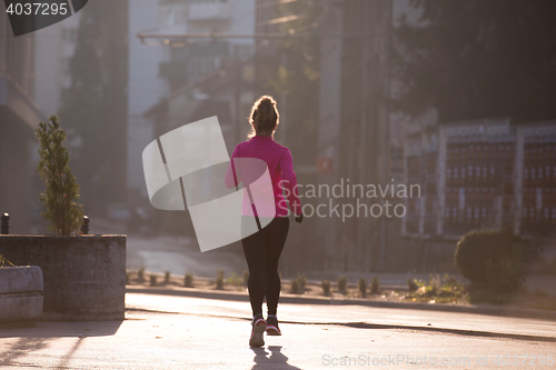 Image of sporty woman jogging on morning