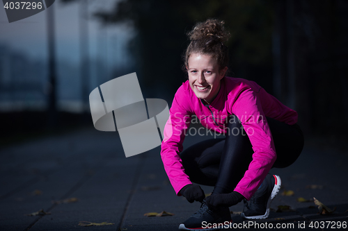 Image of woman  stretching before morning jogging