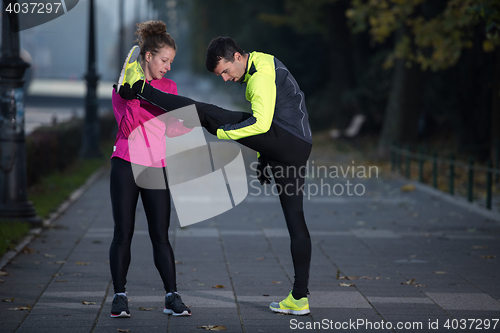 Image of couple warming up before jogging