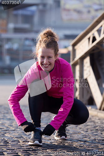 Image of woman  stretching before morning jogging