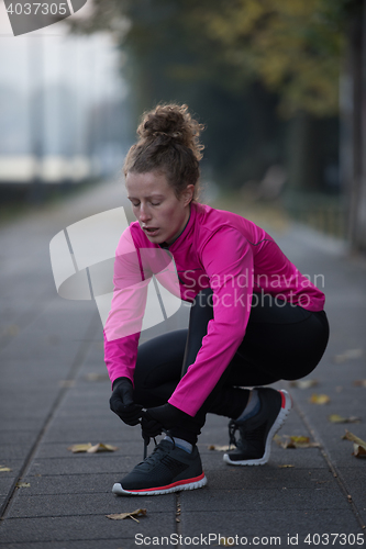 Image of woman  stretching before morning jogging