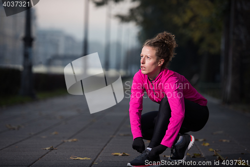 Image of woman  stretching before morning jogging