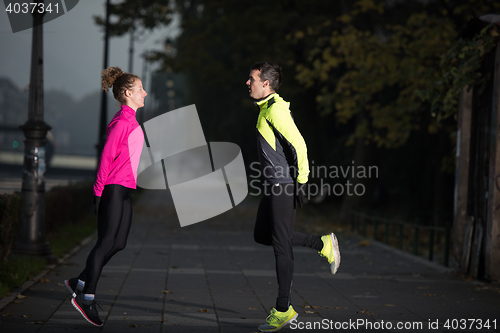 Image of couple warming up before jogging