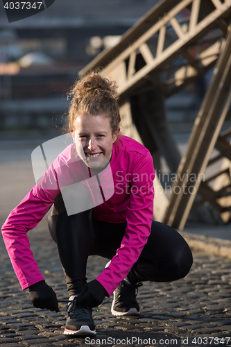 Image of woman  stretching before morning jogging