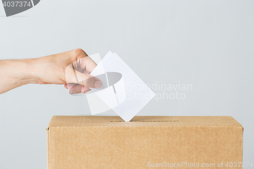 Image of man putting his vote into ballot box on election