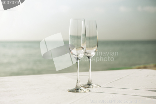 Image of  close up of two champagne glasses on beach 