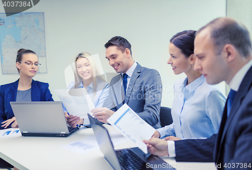 Image of business team with laptop having discussion