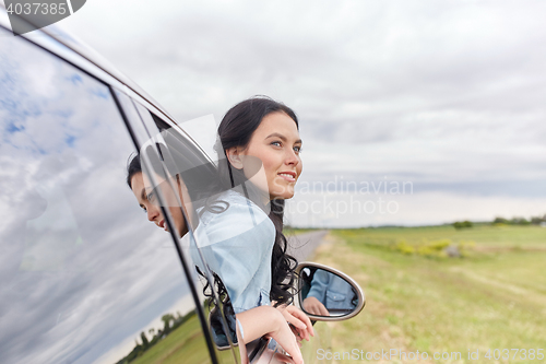 Image of happy young woman driving in car