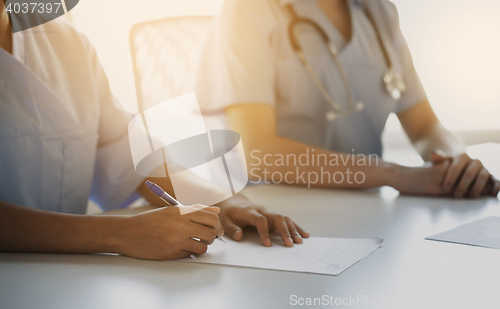Image of close up of doctor taking notes at hospital