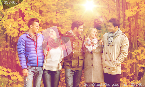 Image of group of smiling men and women in autumn park