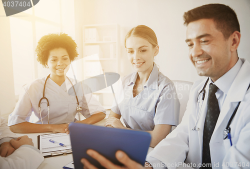 Image of happy doctors with tablet pc meeting at hospital