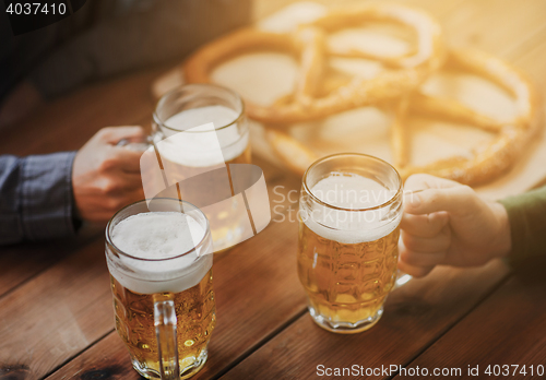 Image of close up of hands with beer mugs at bar or pub