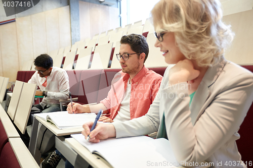 Image of group of students with notebooks at lecture hall