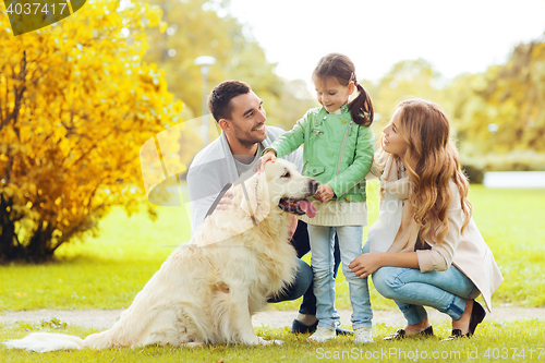 Image of happy family with labrador retriever dog in park