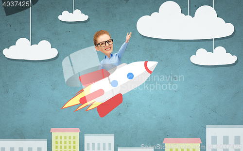 Image of businesswoman flying on rocket above cartoon city