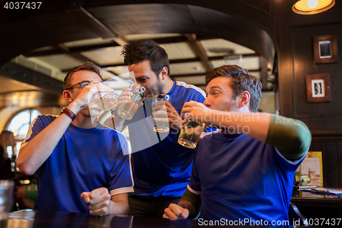 Image of football fans or friends drink beer at sport bar