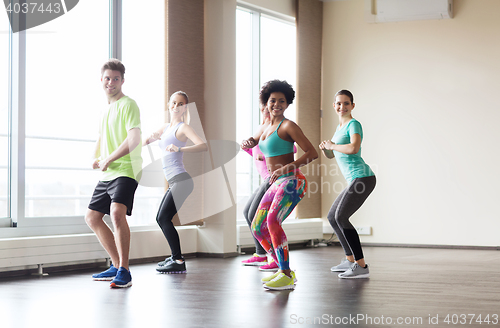 Image of group of smiling people dancing in gym or studio