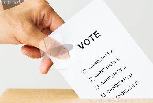 Image of man putting his vote into ballot box on election