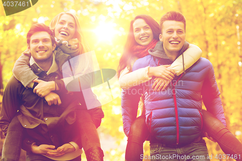 Image of smiling friends having fun in autumn park