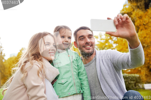 Image of happy family taking selfie by smartphone outdoors