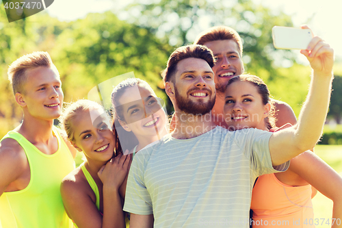 Image of happy friends taking selfie with smartphone