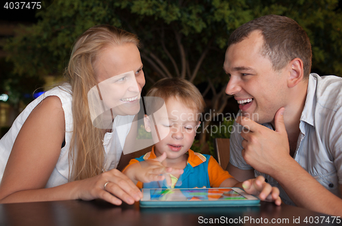 Image of Happy family with tablet PC outdoor in the evening