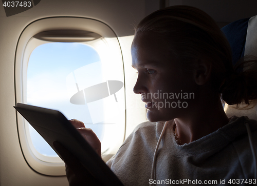 Image of Woman sitting by illuminator in plane with touch pad