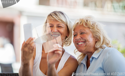 Image of Modern mature women making happy mobile selfie 