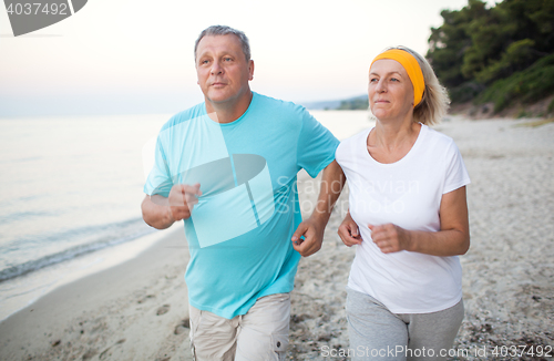 Image of Senior couple jogging on the coast