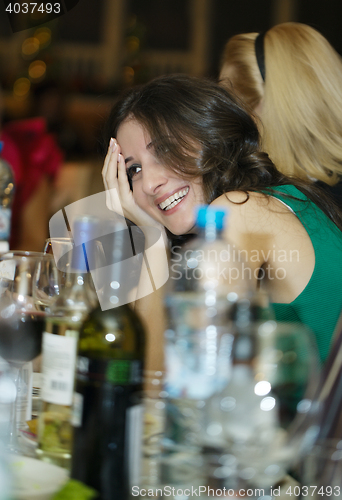 Image of Happy smiling woman sitting at a bar counter