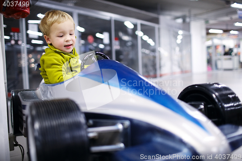 Image of Little boy driving a racing car