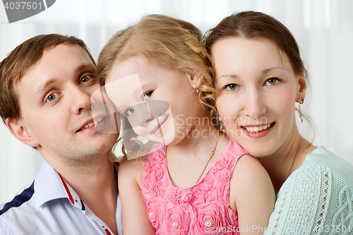 Image of Happy young parents and little daughter