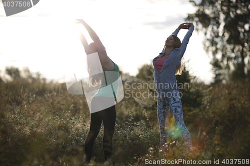 Image of Two young women working out in the garden