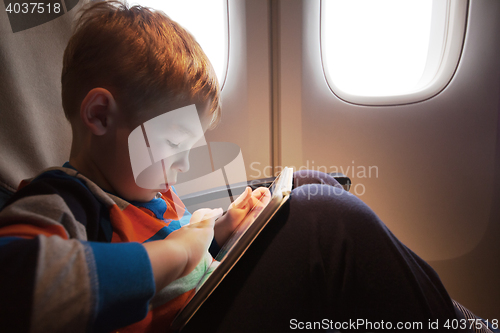 Image of Child using tablet computer during flight