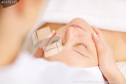 Image of Woman under professional facial massage in beauty spa