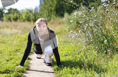 Image of Young woman doing push ups in the park