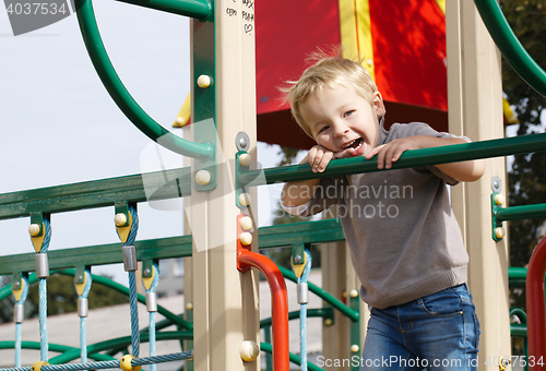 Image of Boy on playground equipment.