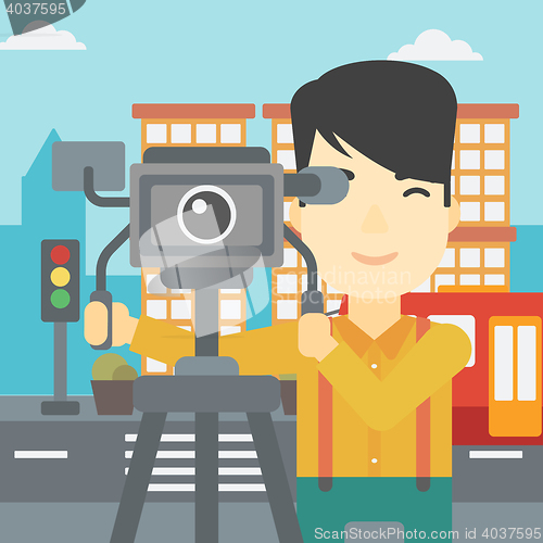 Image of Cameraman with movie camera on tripod.