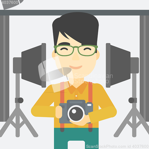 Image of Photographer with camera in photo studio.