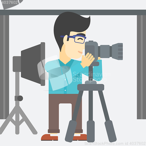 Image of Photographer working with camera on tripod.