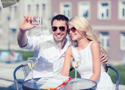 Image of couple taking photo in cafe