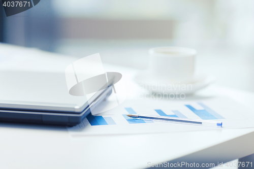 Image of close up of laptop computer, charts and coffee