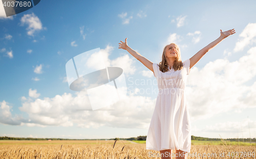 Image of smiling young woman in white dress on cereal field