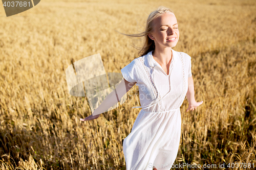 Image of smiling young woman in white dress on cereal field