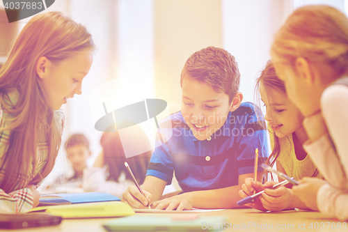 Image of group of students talking and writing at school