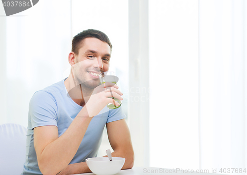 Image of happy man having breakfast at home
