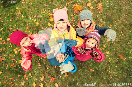 Image of happy children waving hands in autumn park
