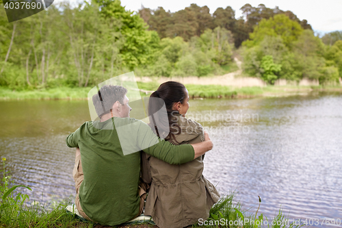 Image of happy couple hugging on lake or river bank