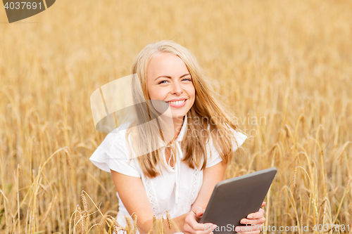 Image of happy young woman with tablet pc on cereal field