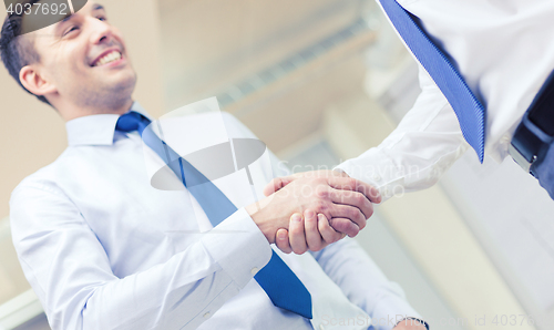 Image of two businessmen shaking hands in office